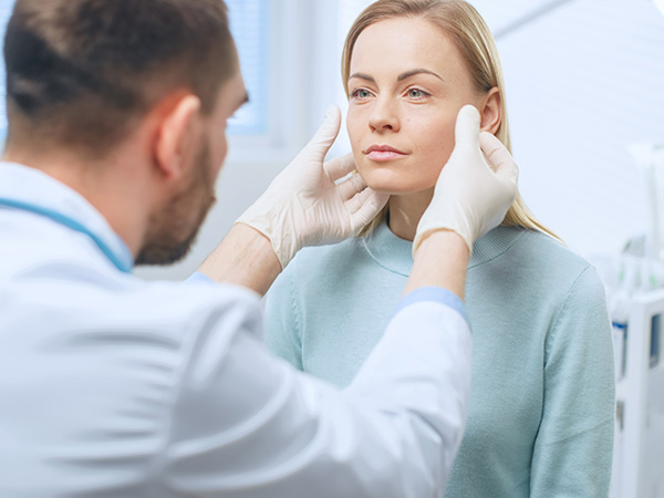 Plastic Surgeon Examines Patient